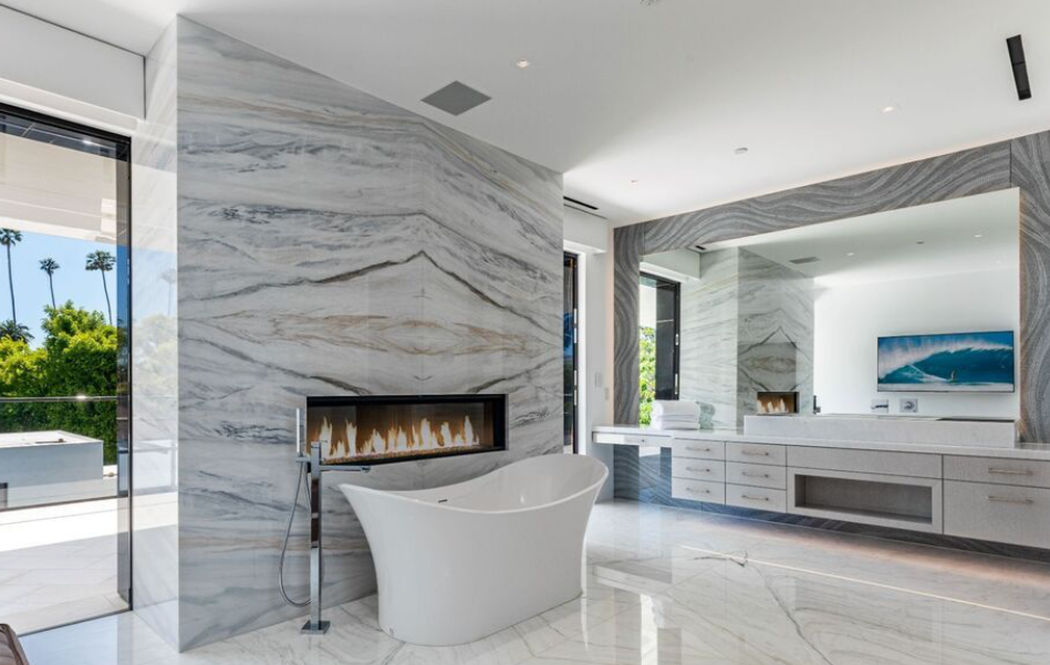 CAD Stone Works double-height book-matched Calacatta marble fireplace and matching stone floor at Beverly Hills Flats Residence.