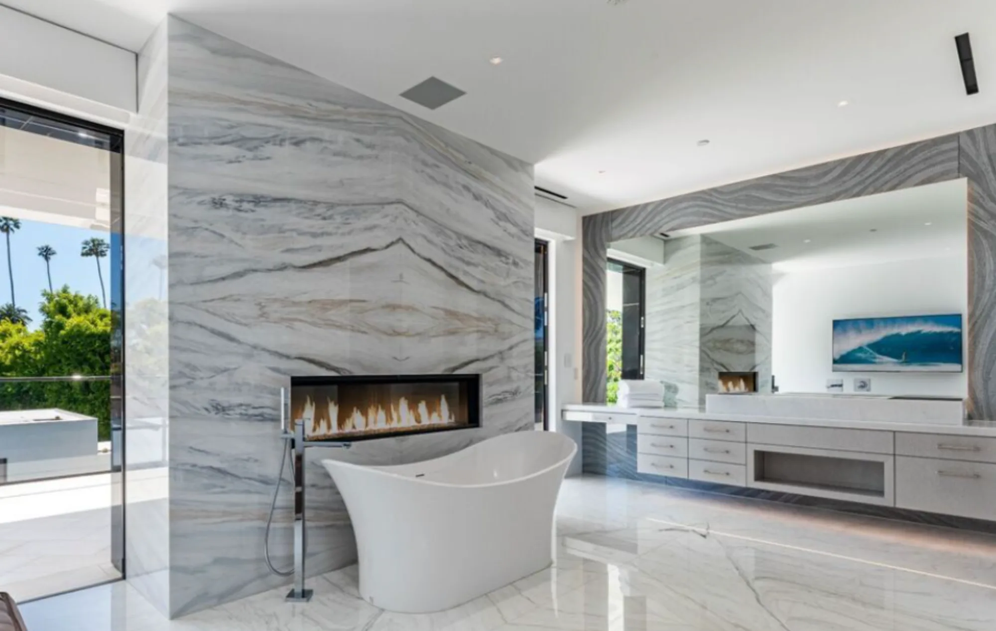 CAD Stone Works double-height book-matched Calacatta marble fireplace and matching stone floor at Beverly Hills Flats Residence.