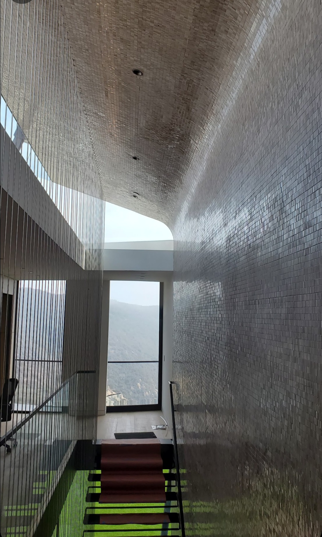 Mosaic tile installation on the curved staircase wall of the Piedra Morada Residence in Pacific Palisades
