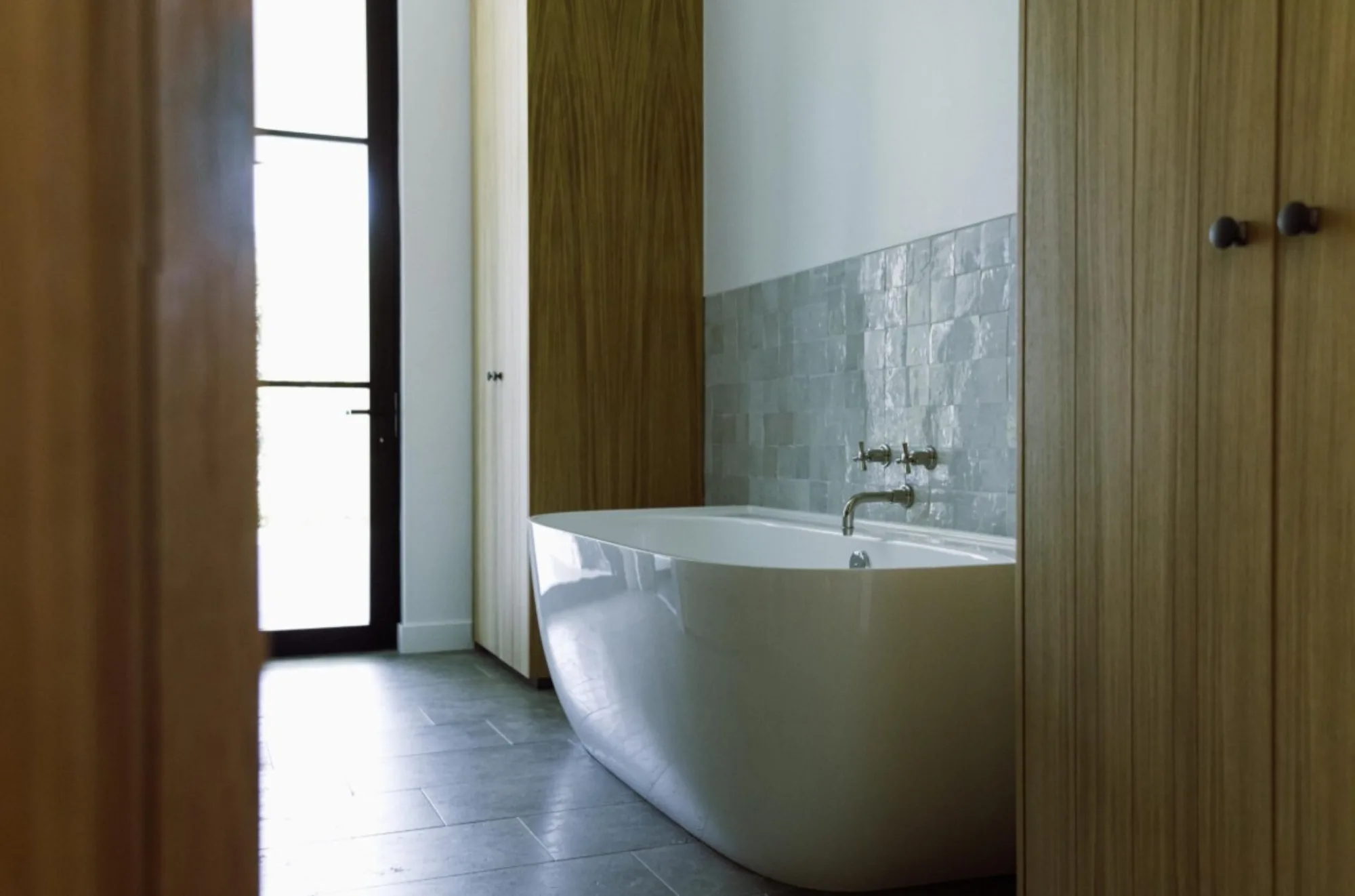 Freestanding bathtub with zellige backsplash in the primary bath at the Lombard Estate in Pacific Palisades, fabricated and installed by CAD Stone Works