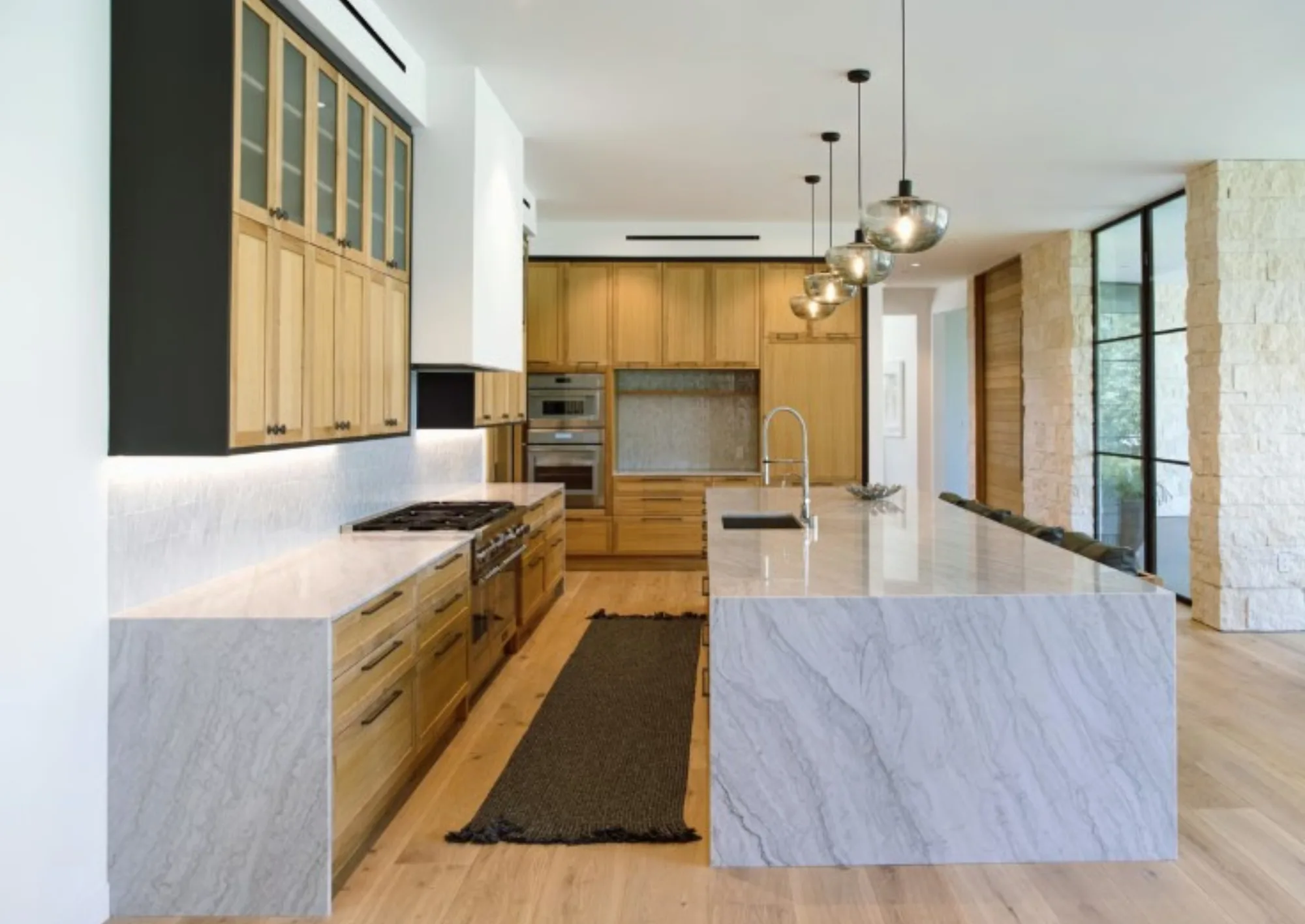 Book matched marble waterfall kitchen island at the Lombard Estate in Pacific Palisades, fabricated and installed by CAD Stone Works