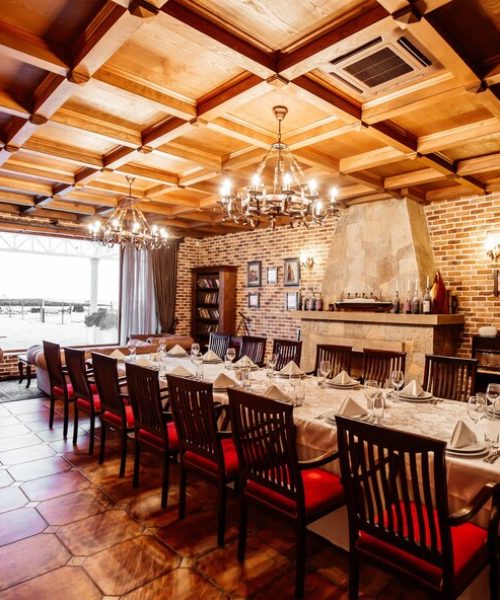 restaurant-private-room-with-table-14-persons-wooden-ceiling-brick-walls-fireplace_140725-8452